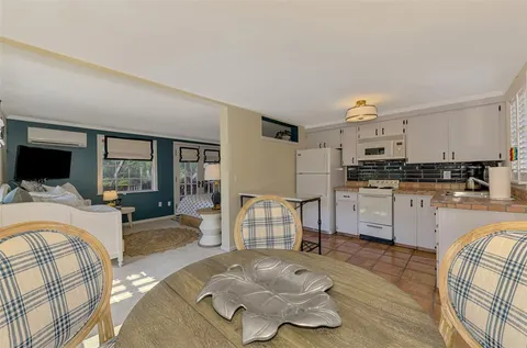 an aerial view of residential houses with outdoor space and trees