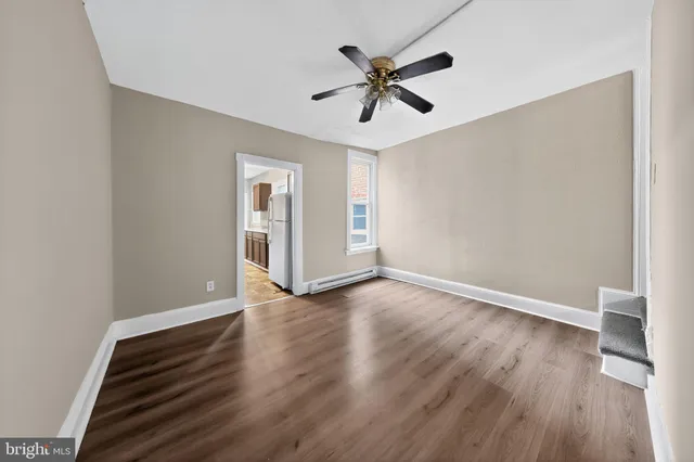 a view of empty room with wooden floor and window