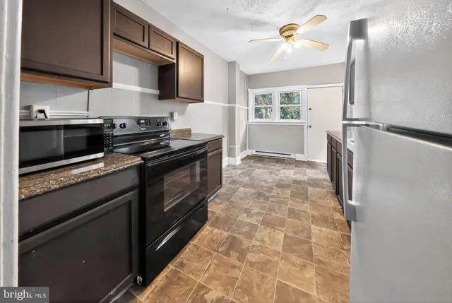 a kitchen with stainless steel appliances a stove microwave and a sink