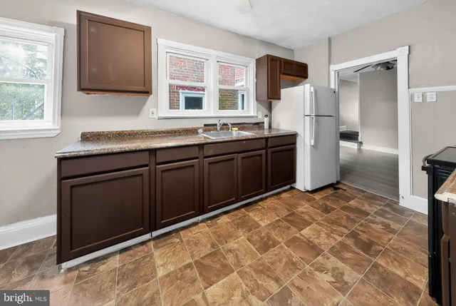 a kitchen with stainless steel appliances granite countertop a refrigerator and a sink