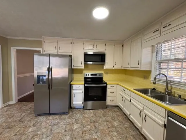 a kitchen with granite countertop a refrigerator and a sink