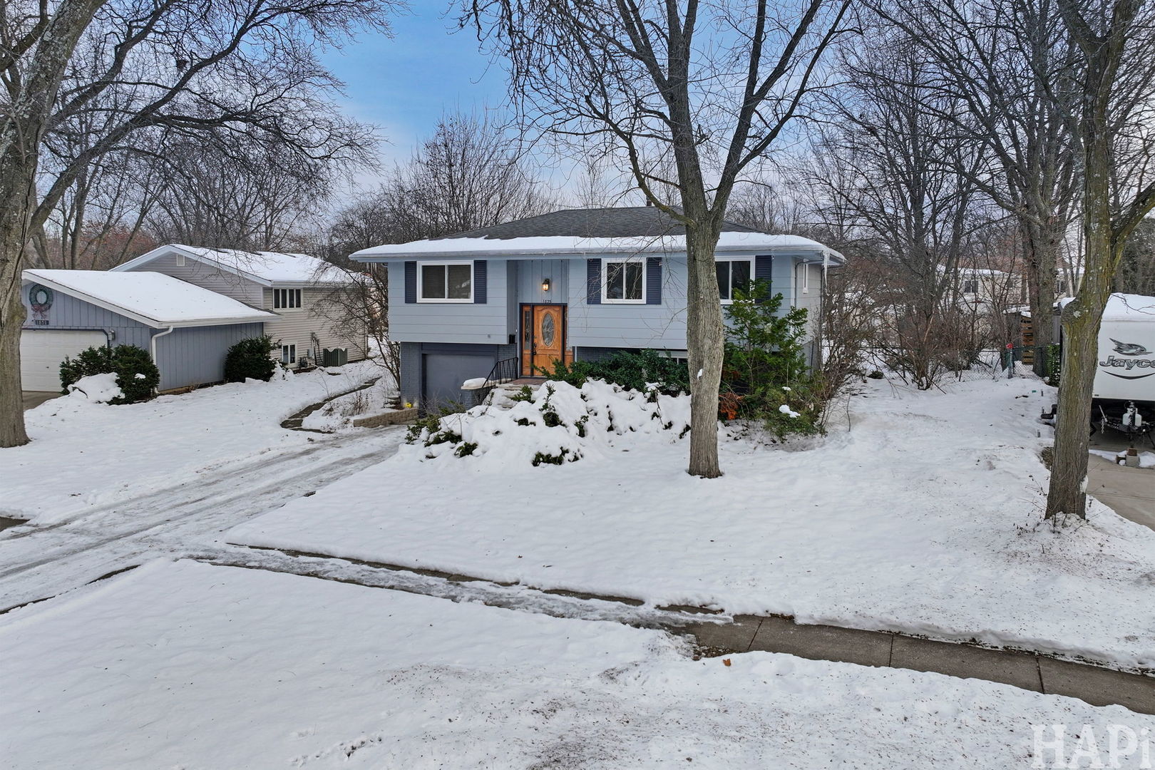 front view of a house with a yard covered in snow