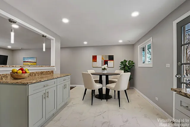 a kitchen with stainless steel appliances kitchen island granite countertop a table and chairs in it