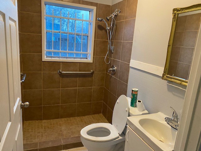 7202 Shotwell Street Houston, TX 77028 - Photo 4 of 8 a white toilet sitting next to a bathroom sink and a shower