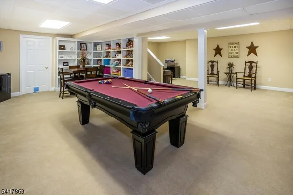 a room with pool table and paintings on the wall