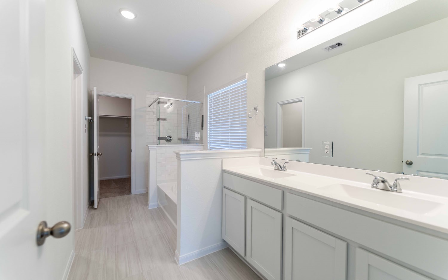 425 Monarch Trail Huntsville, TX 77340 - Photo 11 of 19 a bathroom with a double vanity sink a mirror and a shower