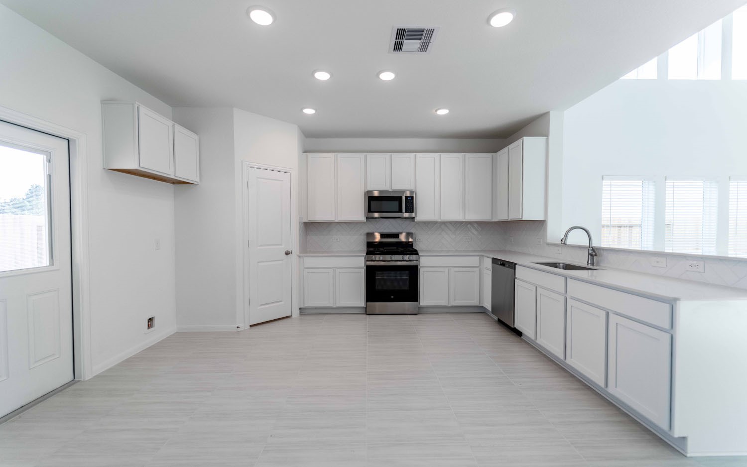 425 Monarch Trail Huntsville, TX 77340 - Photo 8 of 19 a kitchen with granite countertop white cabinets and stainless steel appliances
