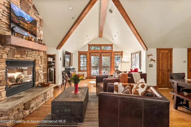 a living room with furniture a fireplace and a floor to ceiling window