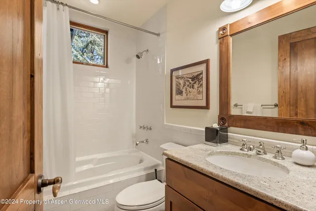 a bathroom with a granite countertop sink toilet and a bathtub