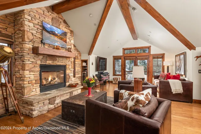 a living room with furniture a fireplace and a floor to ceiling window