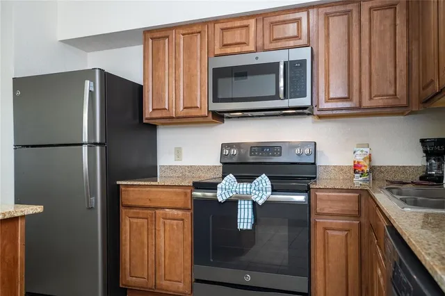 a kitchen with stainless steel appliances granite countertop a refrigerator and a stove top oven