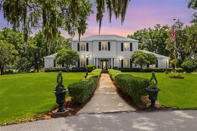 an aerial view of a houses with a yard and lake view