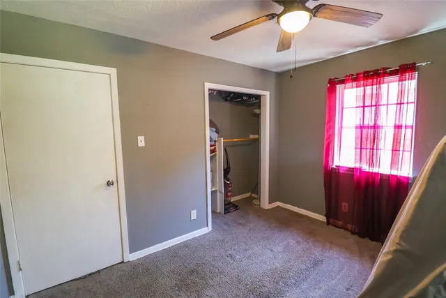 a view of a room with a window and chandelier fan