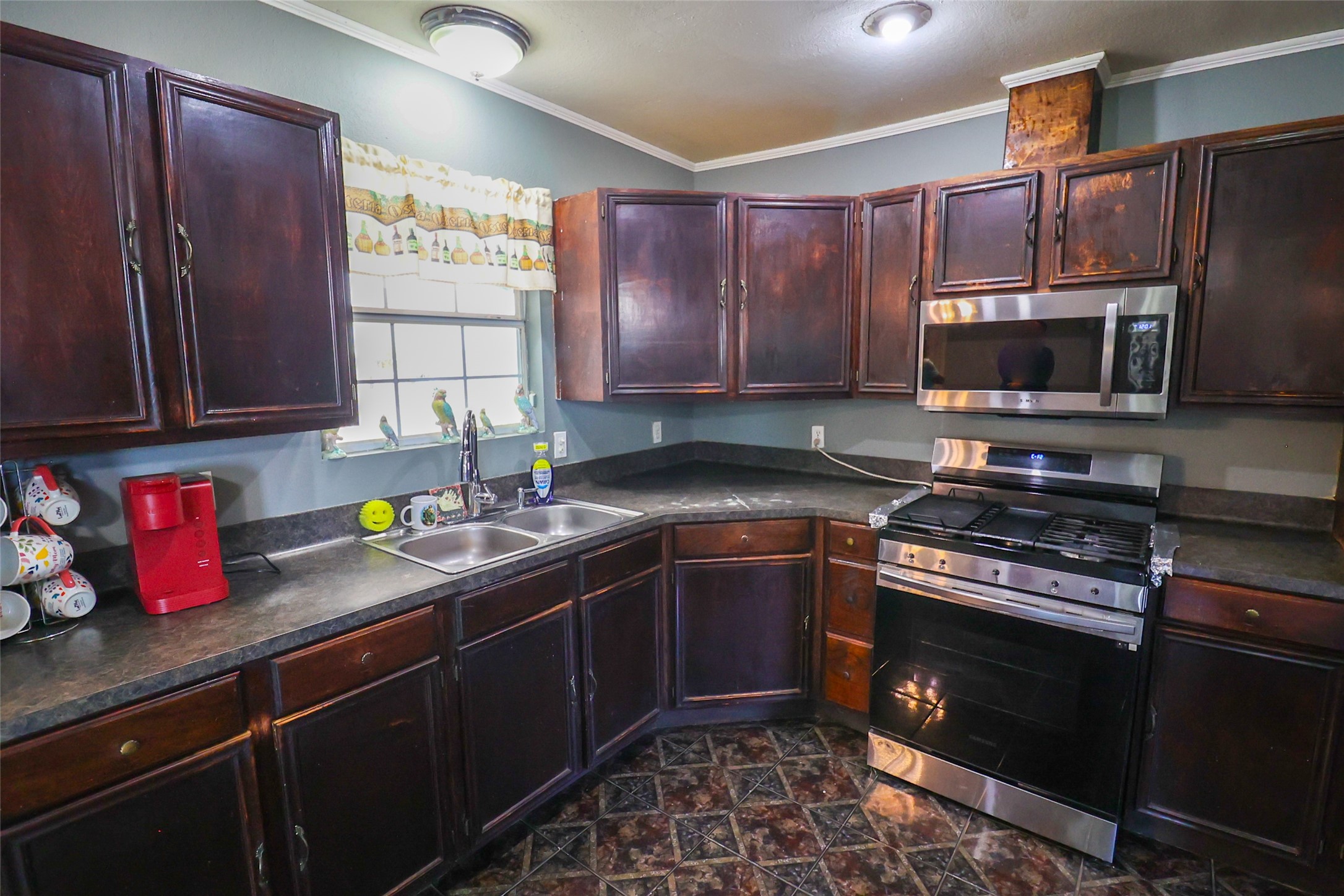 416 Clara Road South Houston, TX 77587 - Photo 7 of 50 a kitchen with granite countertop wooden cabinets stainless steel appliances and a window