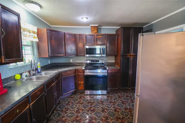 a kitchen with stainless steel appliances granite countertop a sink stove and refrigerator