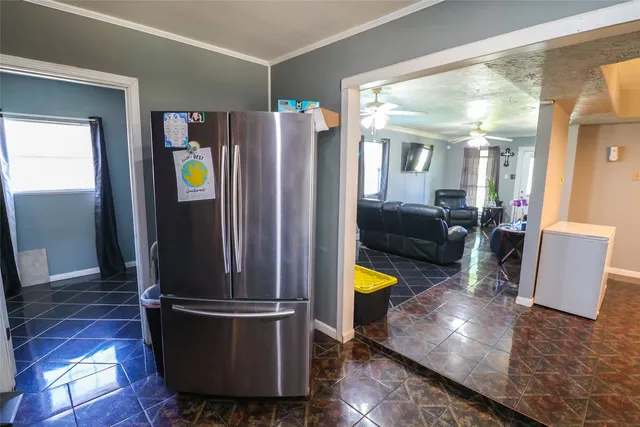 a kitchen with stainless steel appliances wooden floor and a living room