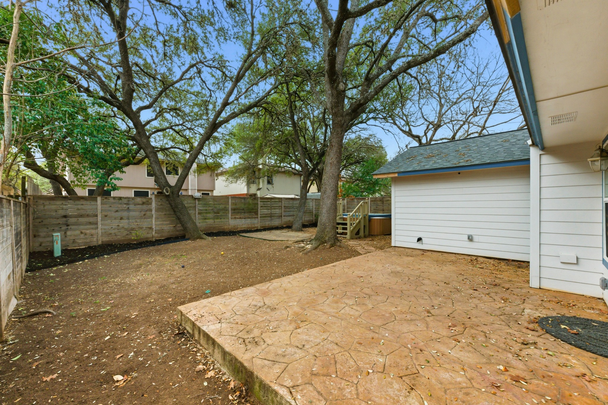 723 Shade Tree Drive Austin, TX 78748 - Photo 18 of 29 a backyard of a house with large trees and a wooden fence