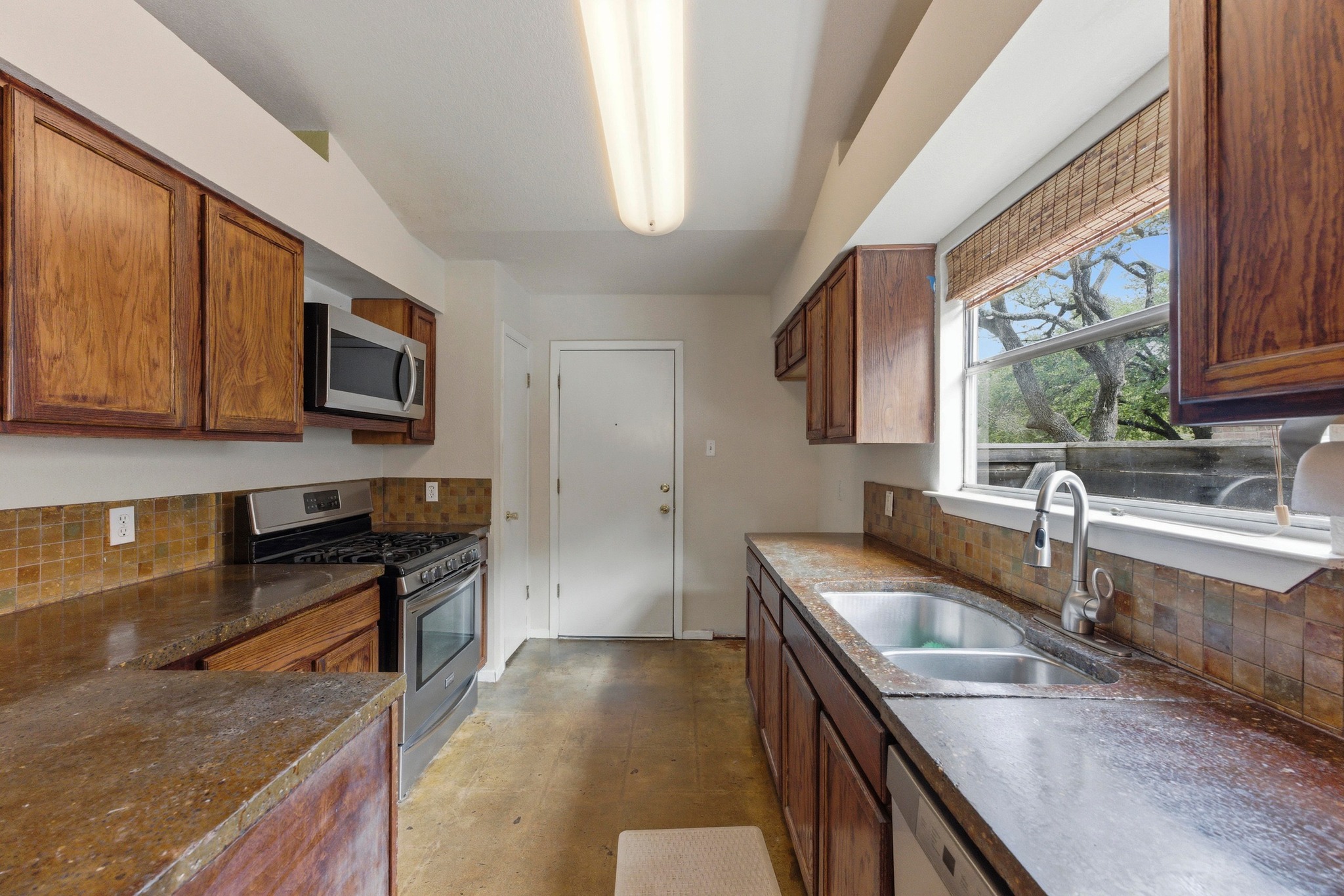 723 Shade Tree Drive Austin, TX 78748 - Photo 7 of 29 a kitchen with stainless steel appliances granite countertop a sink stove and microwave