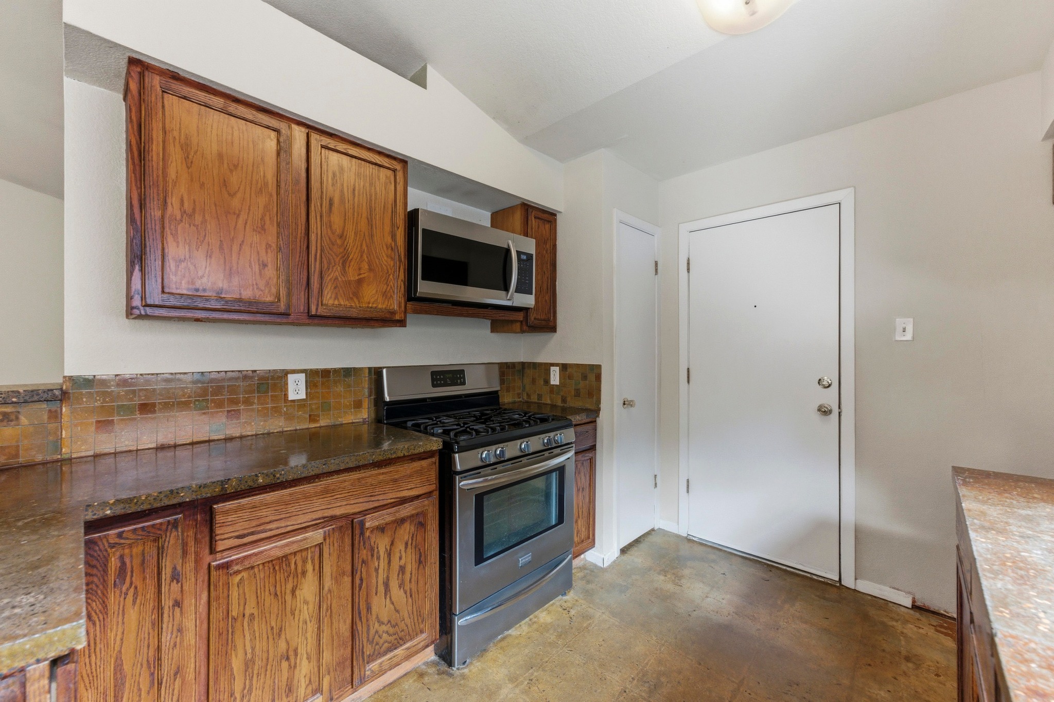 723 Shade Tree Drive Austin, TX 78748 - Photo 8 of 29 a kitchen with stainless steel appliances granite countertop a stove microwave and refrigerator