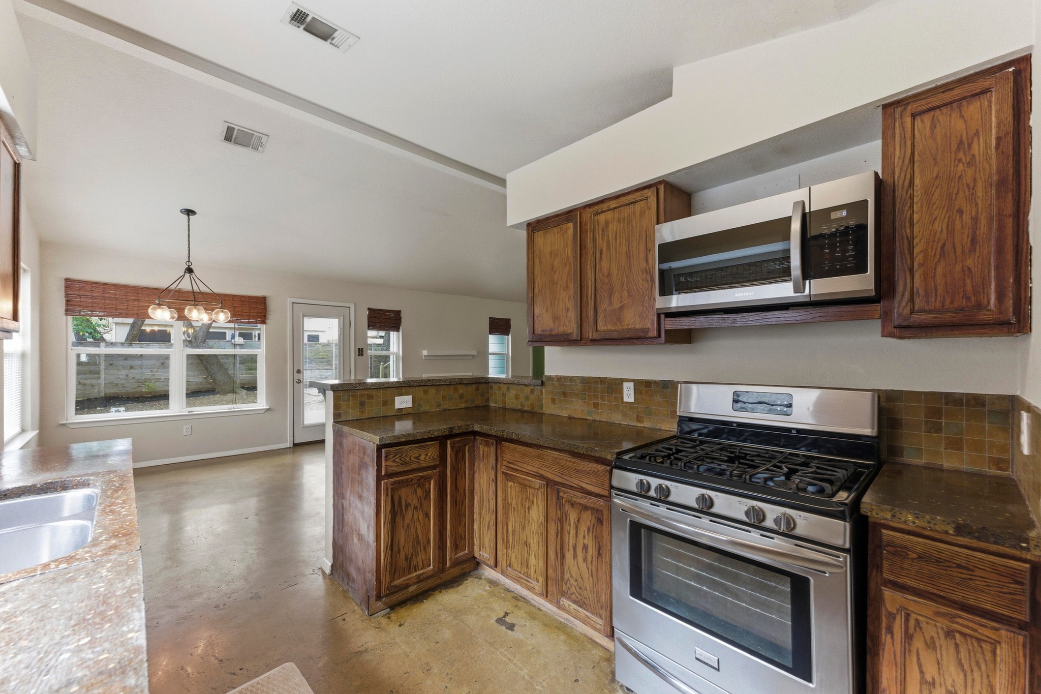 723 Shade Tree Drive Austin, TX 78748 - Photo 9 of 29 a kitchen with stainless steel appliances granite countertop a stove and a microwave