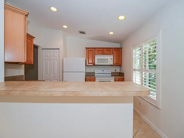 a view of kitchen with stainless steel appliances cabinets and a window