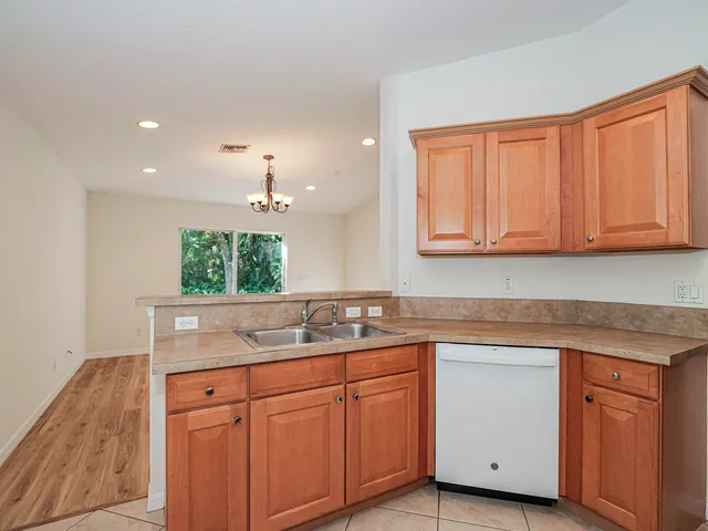 a kitchen with white cabinets and sink