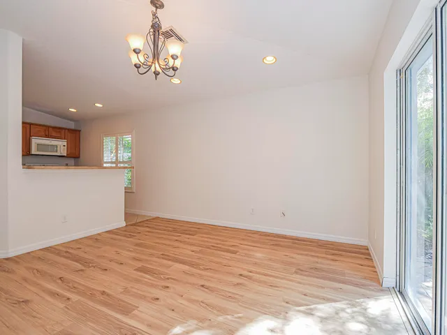 a view of empty room with wooden floor and windows