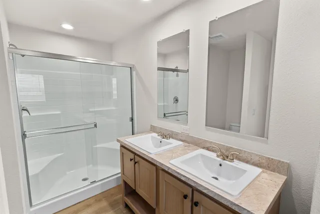 a bathroom with a shower sink vanity and mirror