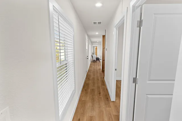 a view of a hallway with wooden floor and staircase