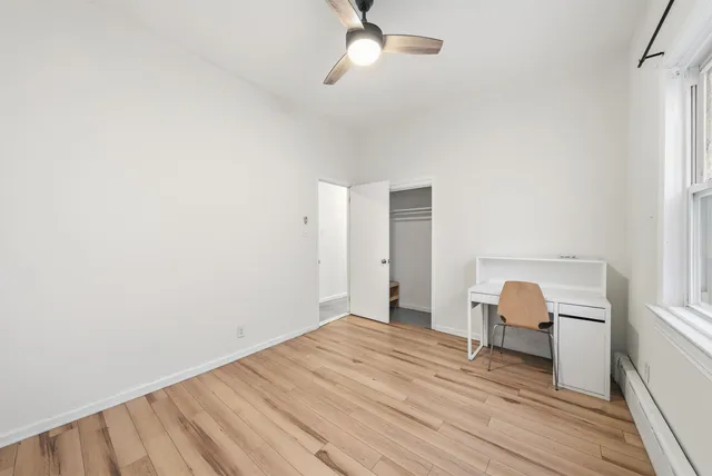 a view of room with wooden floor and ceiling fan