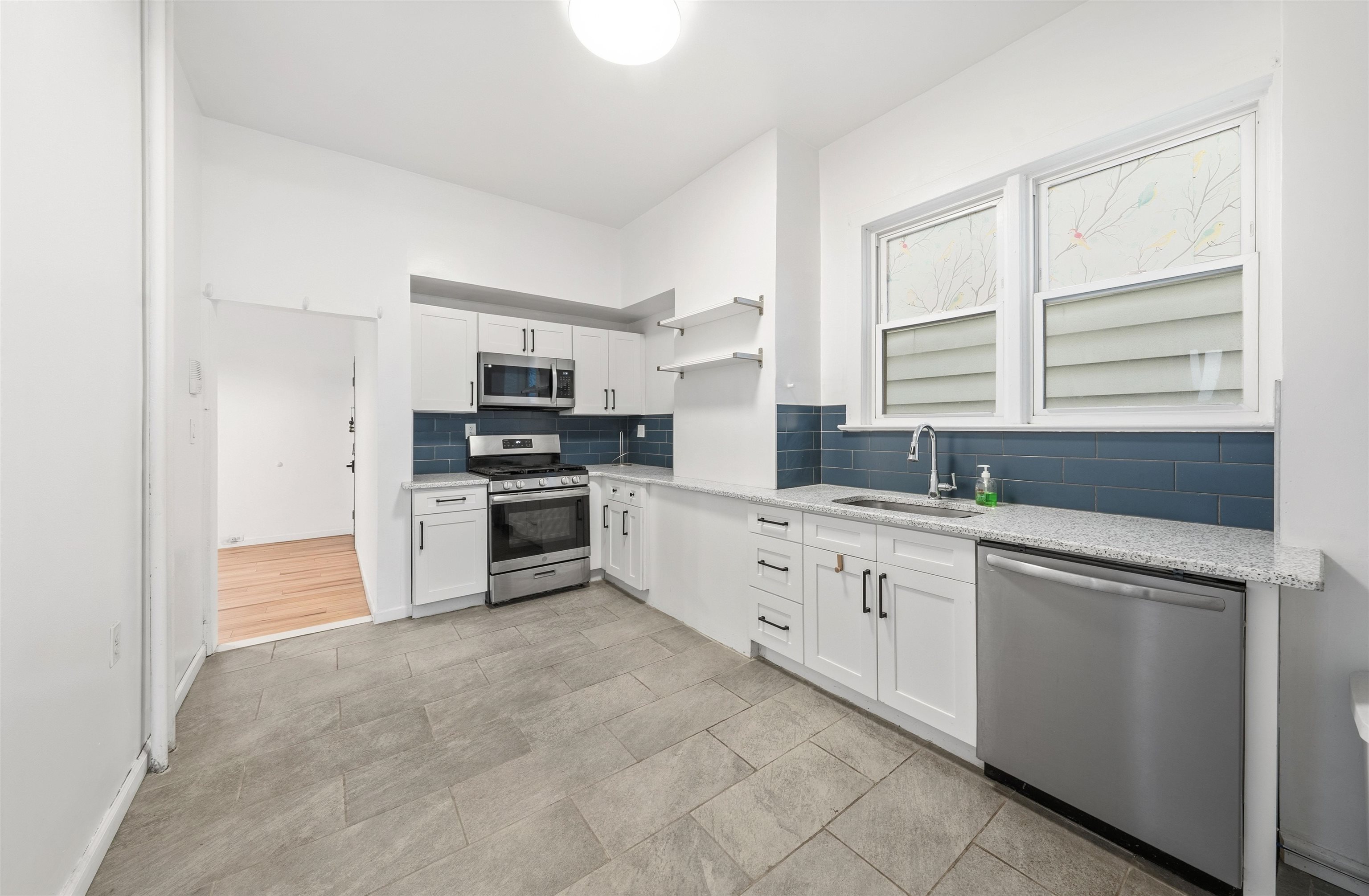 124 73rd Street, Unit 1 North Bergen, NJ 07047 - Photo 9 of 21 a kitchen with granite countertop white cabinets and stainless steel appliances