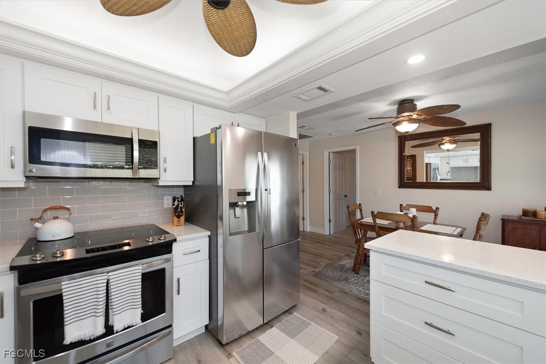 2124 Northeast 3rd Terrace Cape Coral, FL 33909 - Photo 15 of 32 a kitchen with stainless steel appliances granite countertop a sink and a refrigerator