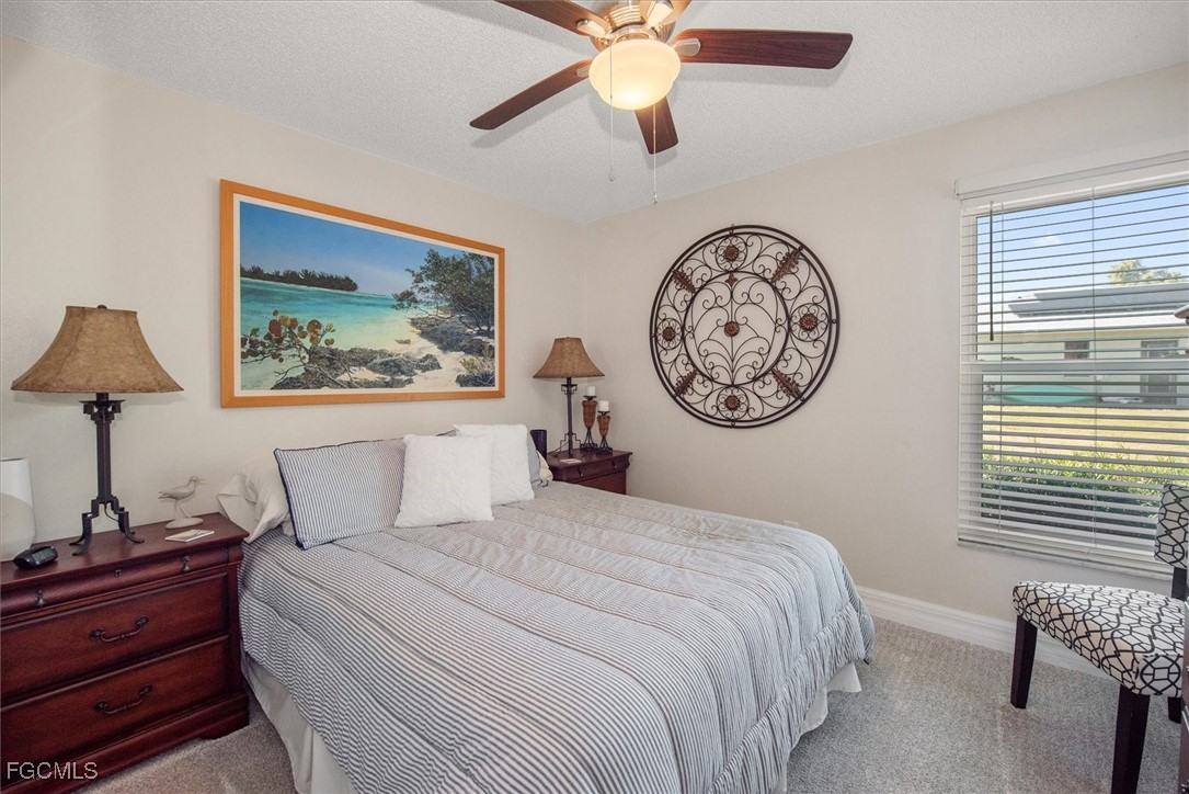 2124 Northeast 3rd Terrace Cape Coral, FL 33909 - Photo 20 of 32 a bedroom with a large bed and a lamp