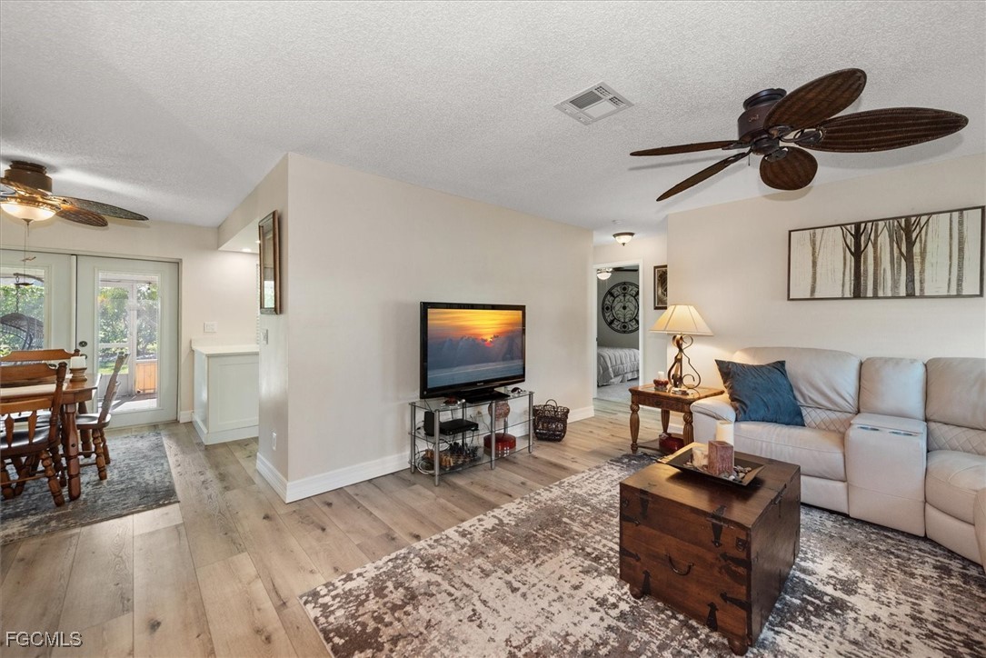 2124 Northeast 3rd Terrace Cape Coral, FL 33909 - Photo 3 of 32 a living room with furniture and wooden floor