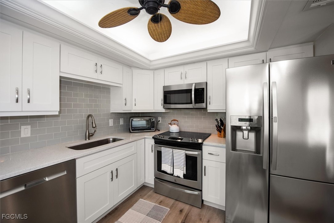 2124 Northeast 3rd Terrace Cape Coral, FL 33909 - Photo 4 of 32 a kitchen with a refrigerator stainless steel appliances cabinets and a counter space