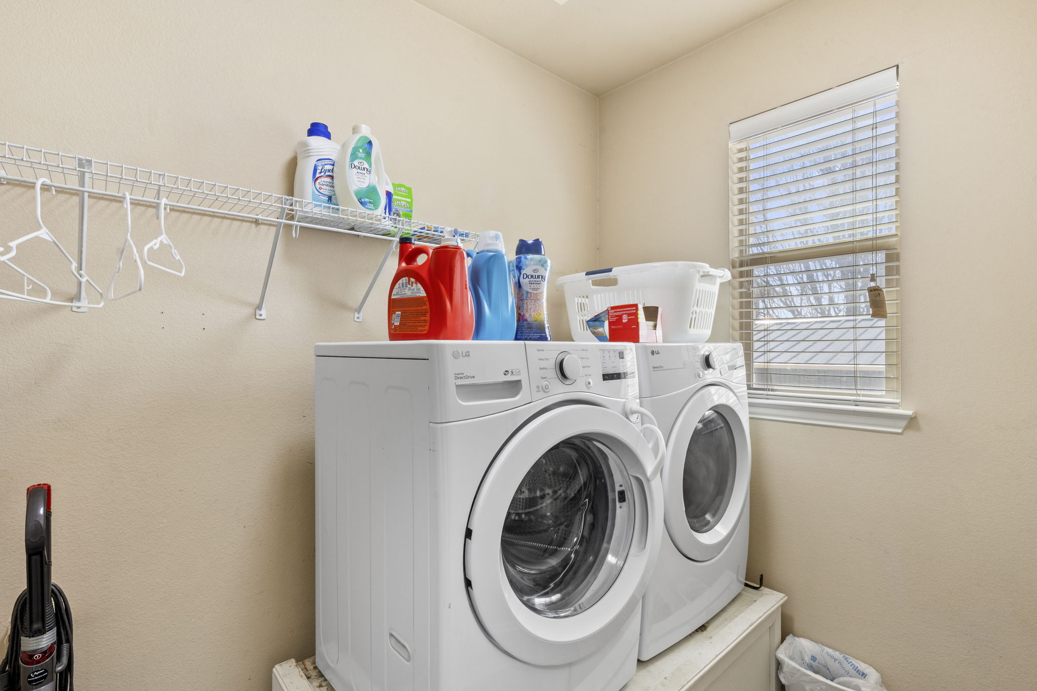 227 Sandstone Trail Buda, TX 78610 - Photo 31 of 33 Dedicated laundry room featuring a window with blinds, upper wire shelving, and neutral wall paint