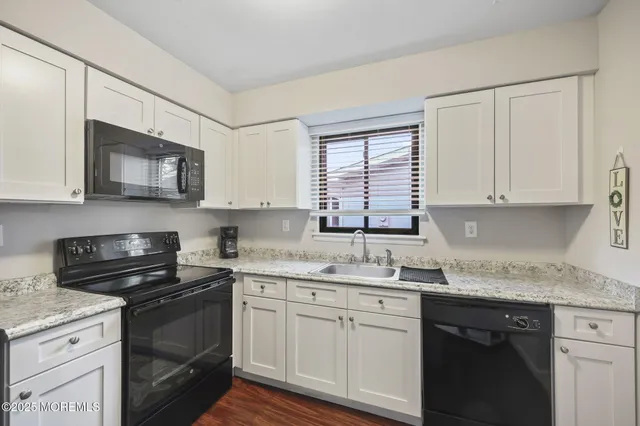 a kitchen with stainless steel appliances granite countertop white cabinets granite counter tops and a window