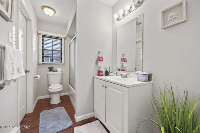 a bathroom with a sink a toilet and a large mirror