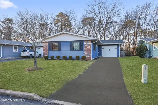 a front view of a house with a yard and trees