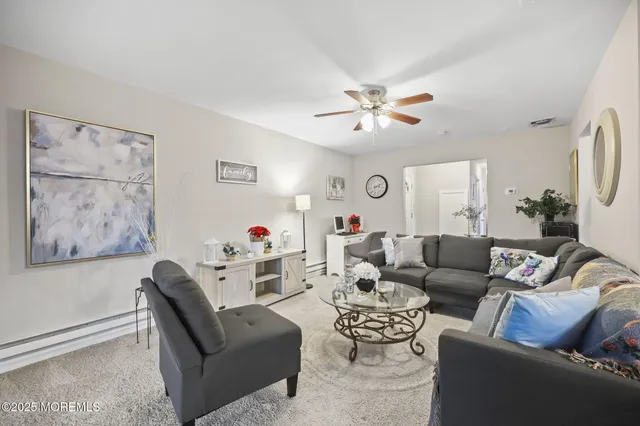 a living room with furniture a couch and a ceiling fan