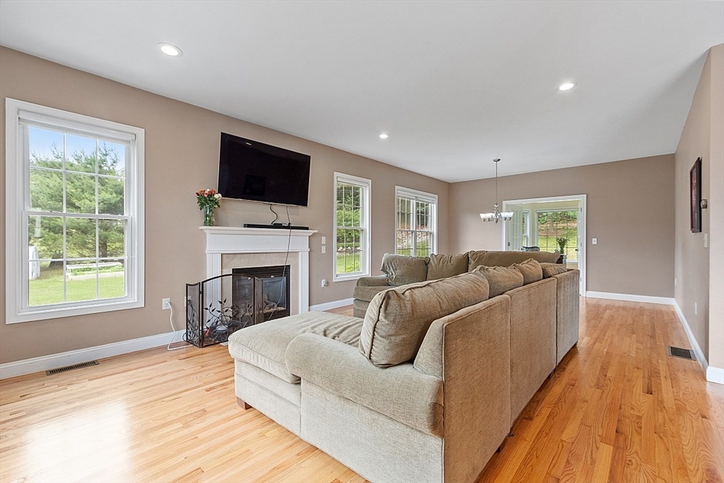 204 Littleton County Road Harvard, MA 01451 - Photo 14 of 42 a living room with furniture a flat screen tv and a fireplace