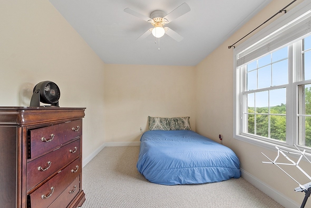 204 Littleton County Road Harvard, MA 01451 - Photo 25 of 42 a bedroom with a bed and a chandelier
