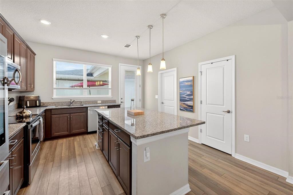 2100 Gopher Tortoise Terrace Oakland, FL 34787 - Photo 11 of 58 a kitchen with stainless steel appliances granite countertop a kitchen island hardwood floor sink stove and large window