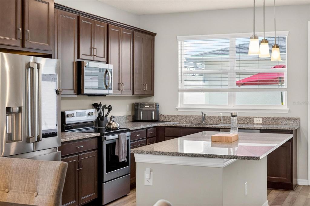 2100 Gopher Tortoise Terrace Oakland, FL 34787 - Photo 21 of 58 a kitchen with stainless steel appliances granite countertop a sink stove and refrigerator
