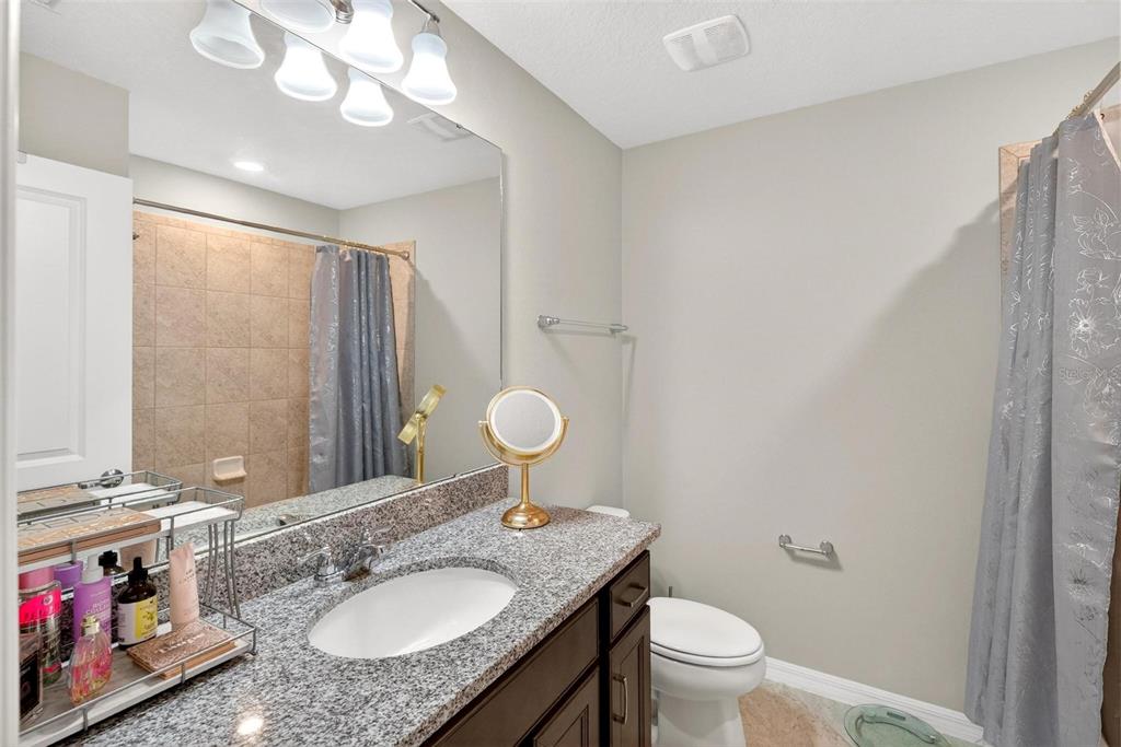 2100 Gopher Tortoise Terrace Oakland, FL 34787 - Photo 23 of 58 a bathroom with a granite countertop sink toilet and a mirror