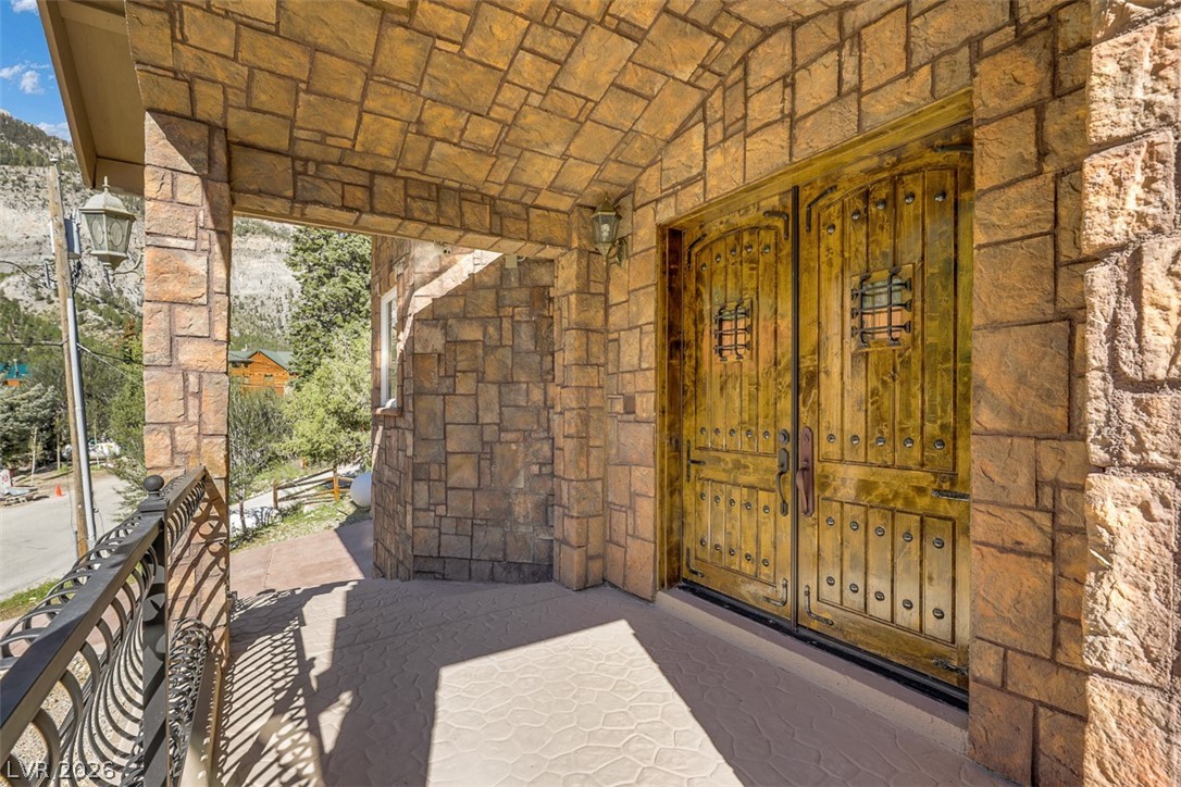 264 Crestview Drive Mount Charleston, NV 89124 - Photo 11 of 78 This entry features intricate wooden doors and robust stone construction, blending strength with elegant design.