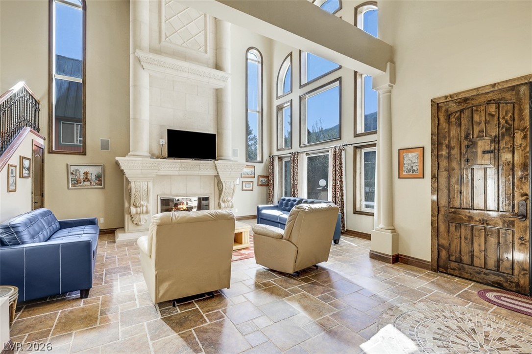 264 Crestview Drive Mount Charleston, NV 89124 - Photo 13 of 78 This living room features expansive windows, a grand fireplace, and intricate flooring.