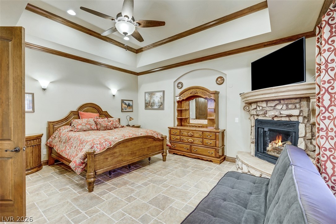 264 Crestview Drive Mount Charleston, NV 89124 - Photo 40 of 78 Relax in this inviting bedroom featuring a fireplace, tray ceiling, and a ceiling fan.