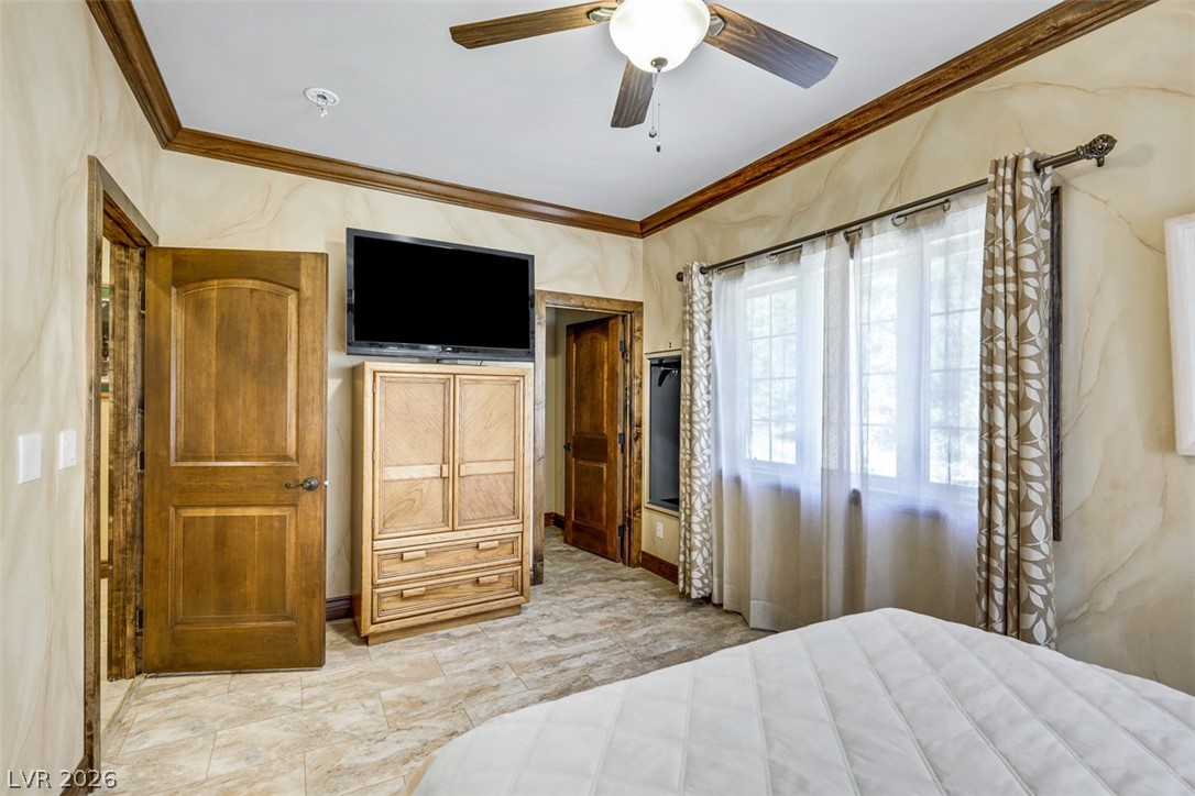 264 Crestview Drive Mount Charleston, NV 89124 - Photo 47 of 78 This cozy bedroom features warm wood trim, a ceiling fan, and tiled flooring, creating a comfortable retreat.