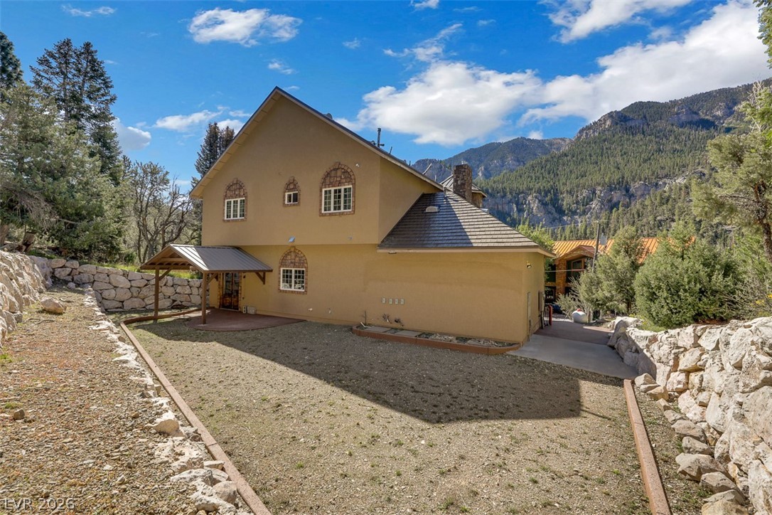 264 Crestview Drive Mount Charleston, NV 89124 - Photo 69 of 78 This residence features a stucco exterior and pitched rooflines, nestled within a serene, mountainous landscape.
